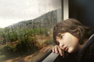 boy at window on rainy day